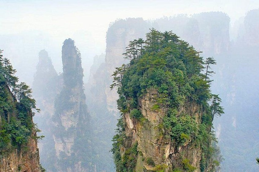 A mountainous landscape with towering cliffs and dense vegetation. 4