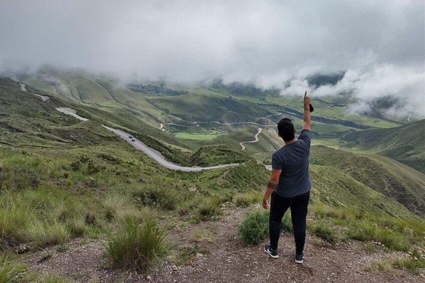 Una persona está de pie en una colina con vistas a un camino sinuoso y un valle. 2