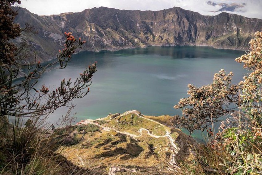 A lake surrounded by mountains, with a path leading to the water's edge. 1