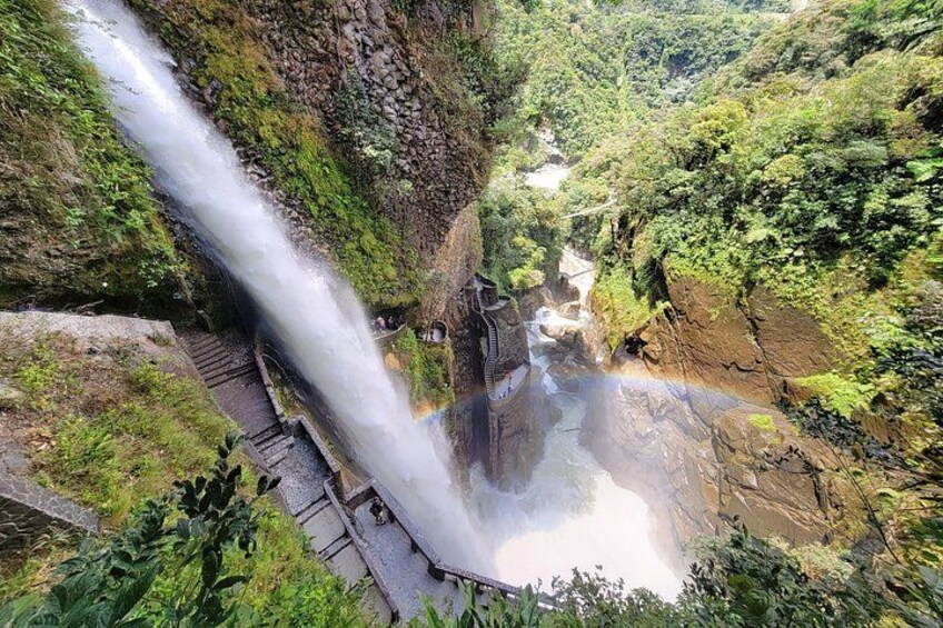 A waterfall cascading down a rocky cliff, surrounded by lush greenery. 2