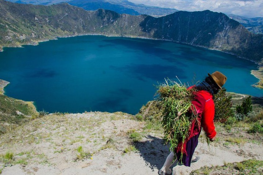 A person hiking with a backpack on a mountain trail overlooking a lake. 1