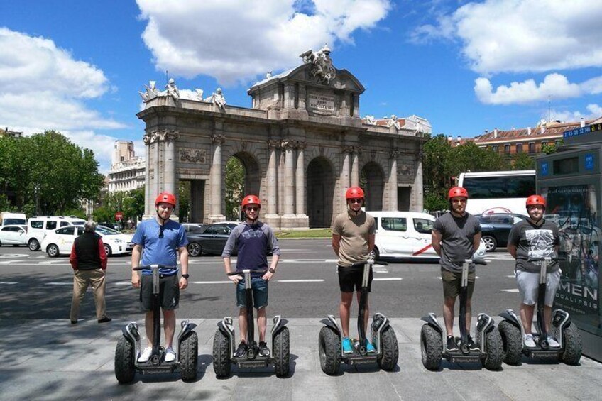 Cinq personnes sur des Segways devant un grand monument en pierre. 1