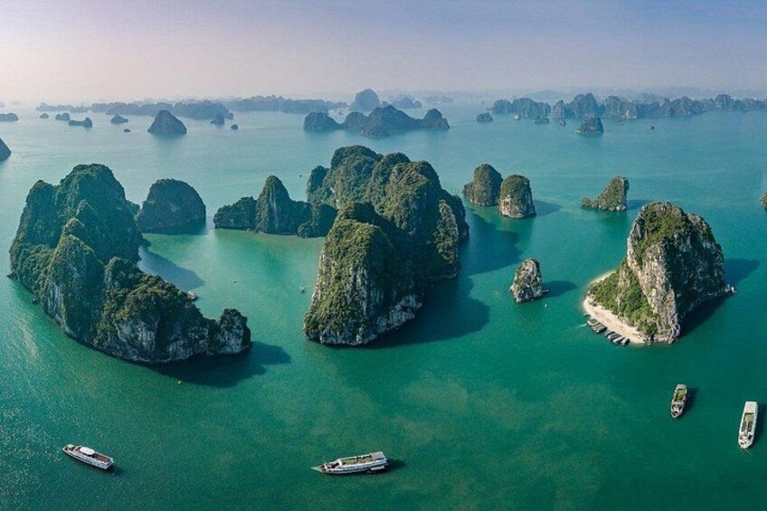 A coastal landscape with numerous limestone islands surrounded by turquoise waters. 1
