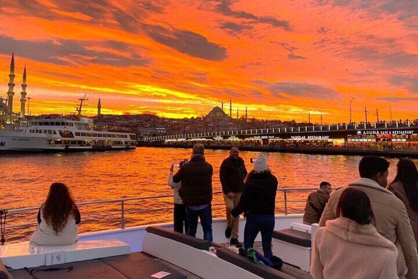 Un tramonto su una riva con persone su una barca e una moschea sullo sfondo. 1