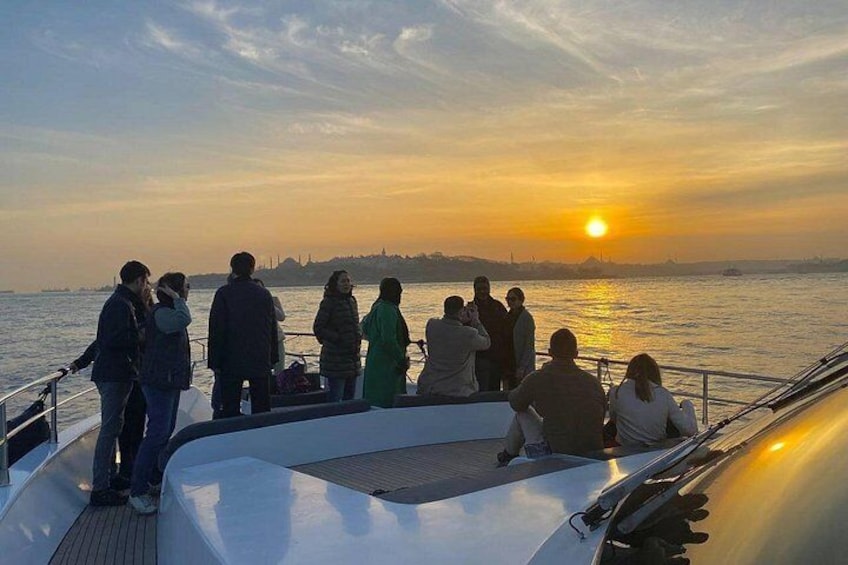 Tramonto su uno specchio d'acqua con persone a bordo di una barca. 2