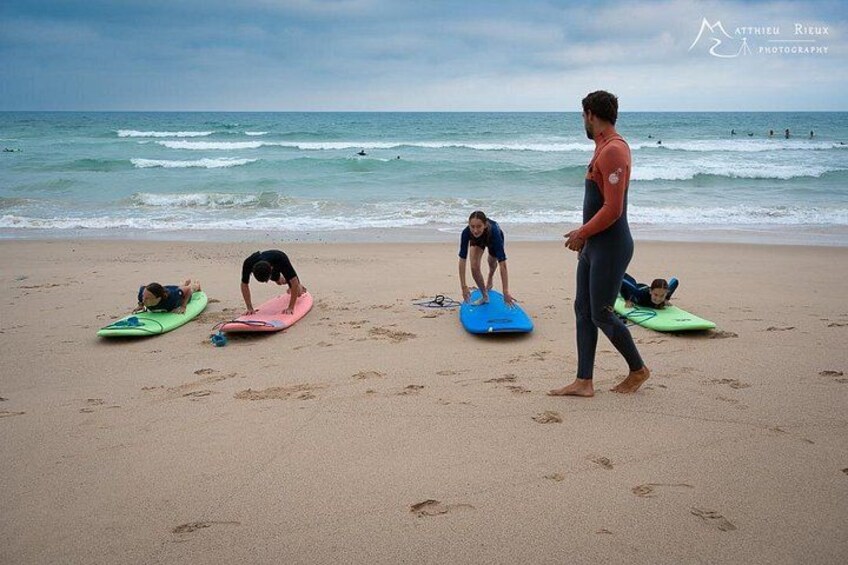 A beach with people on surfboards, ocean waves, and a clear sky. 1