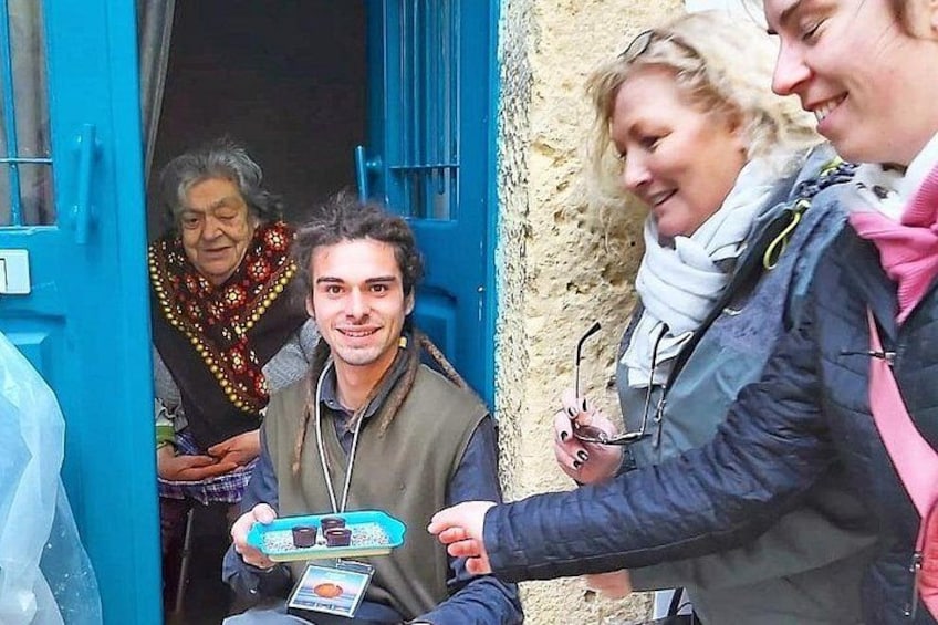 A person holding a tray with a drink and a card, standing next to a blue door. 5