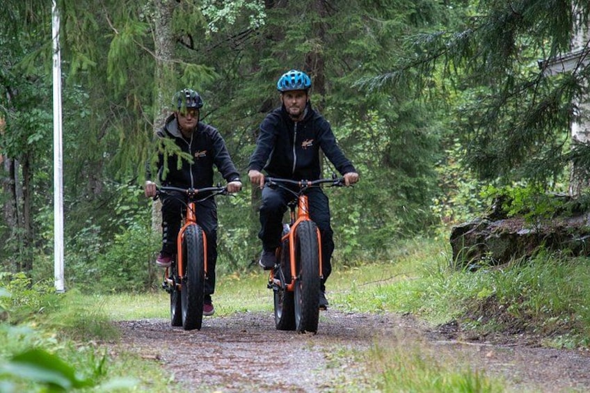Two people riding mountain bikes on a forest trail. 3