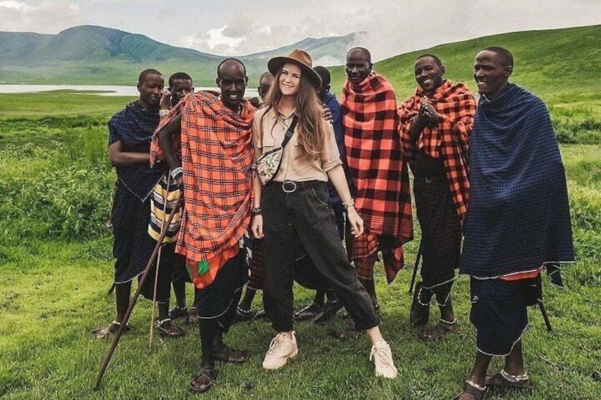 A group of people in a grassy field with mountains in the background. 5