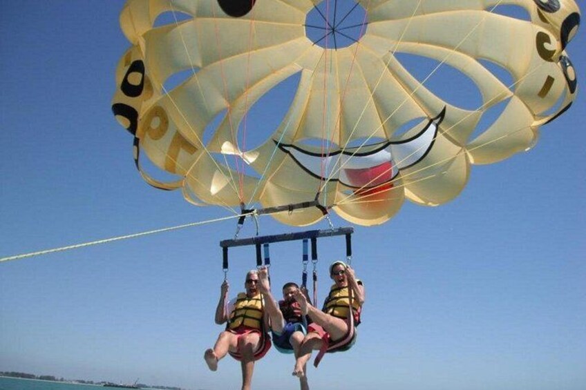 Tre personer parasailer over vandet. 1
