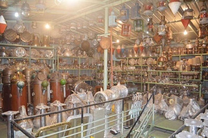 A cluttered antique shop filled with various old metal objects and glassware. 2