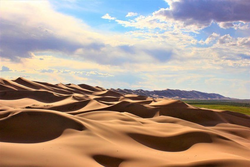 Sanddünen mit einer Bergkette im Hintergrund. 1