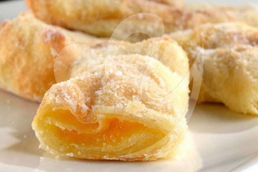 Ein Gebäck mit knuspriger, goldbrauner Kruste und sichtbarer Füllung. 2