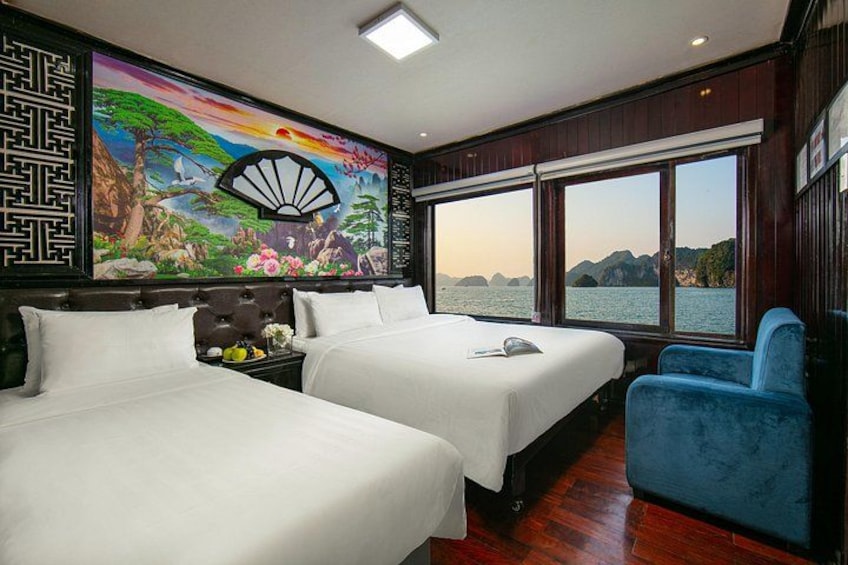 A room with two beds, a large window, and a mural. 2