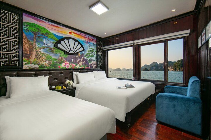 A room with two beds, a blue chair, a large window, and a mural. 3