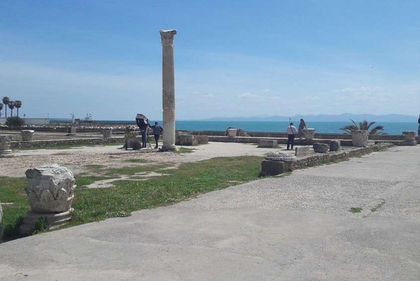 Rovine antiche con colonne, cielo sereno e vista sul mare in lontananza. 3