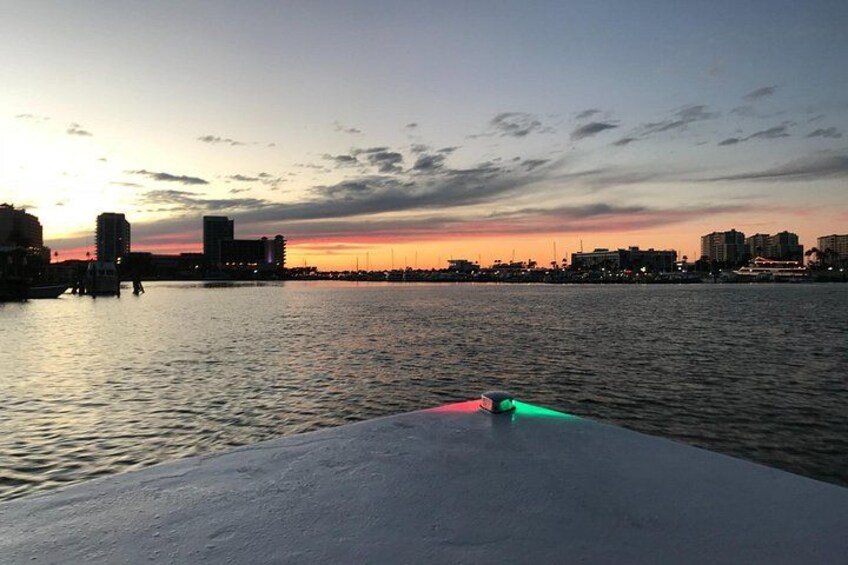 A sunset over a body of water with buildings in the background. 5