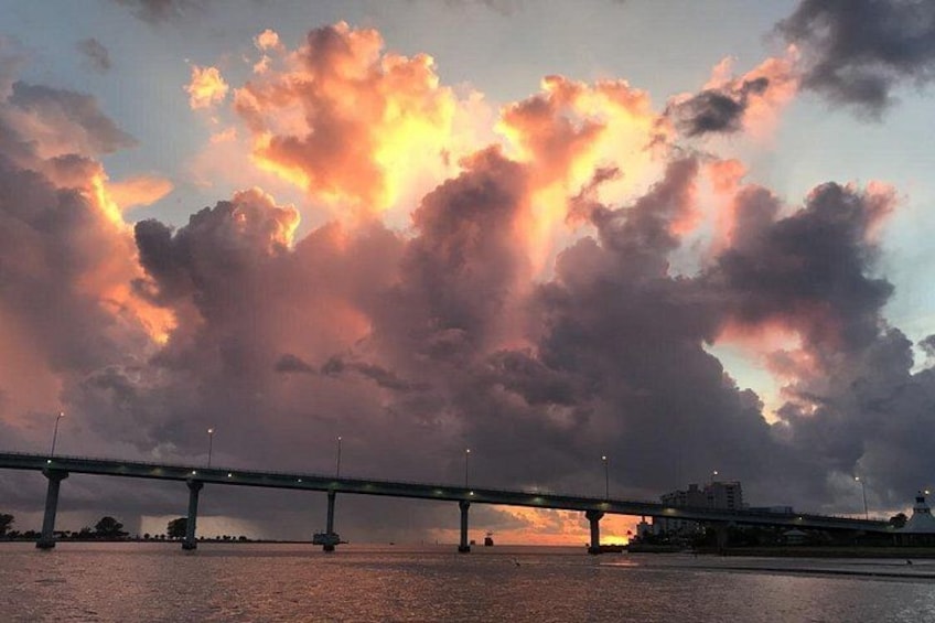 A bridge over water with dramatic clouds in the sky. 2