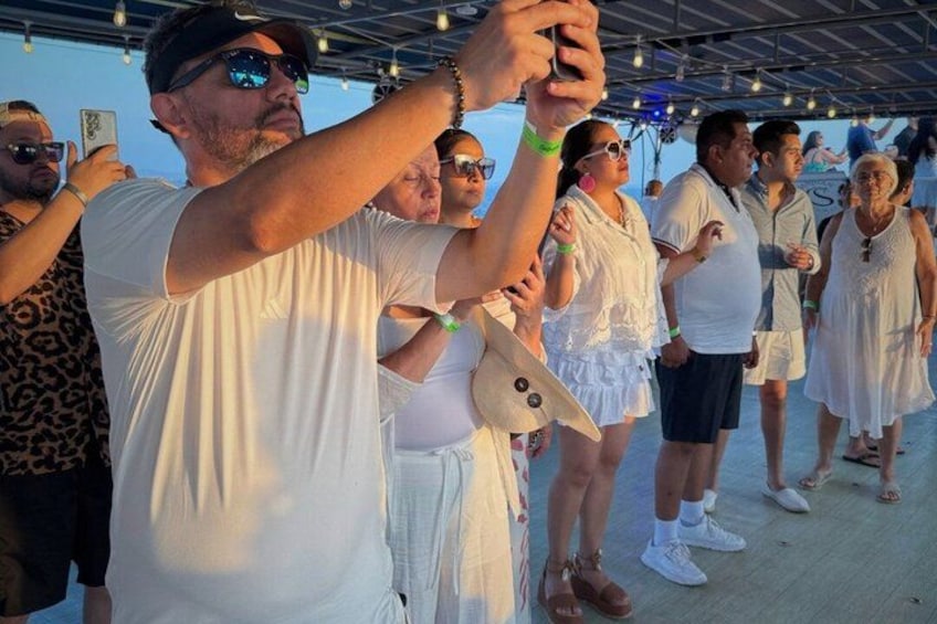 A group of people standing outdoors, some holding smartphones. 3