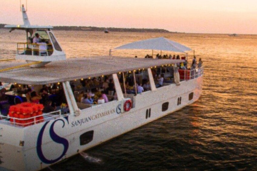 A boat with passengers, a lifebuoy, and a logo on the side. 1