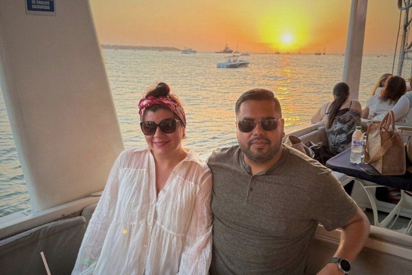 A couple on a boat with a sunset in the background. 2