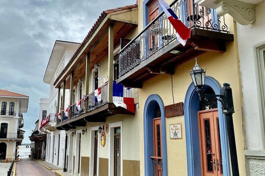 A street with buildings, balconies, and flags. 3