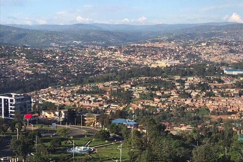 Un paisaje urbano con una rotonda central, edificios y una cadena montañosa a lo lejos. 4
