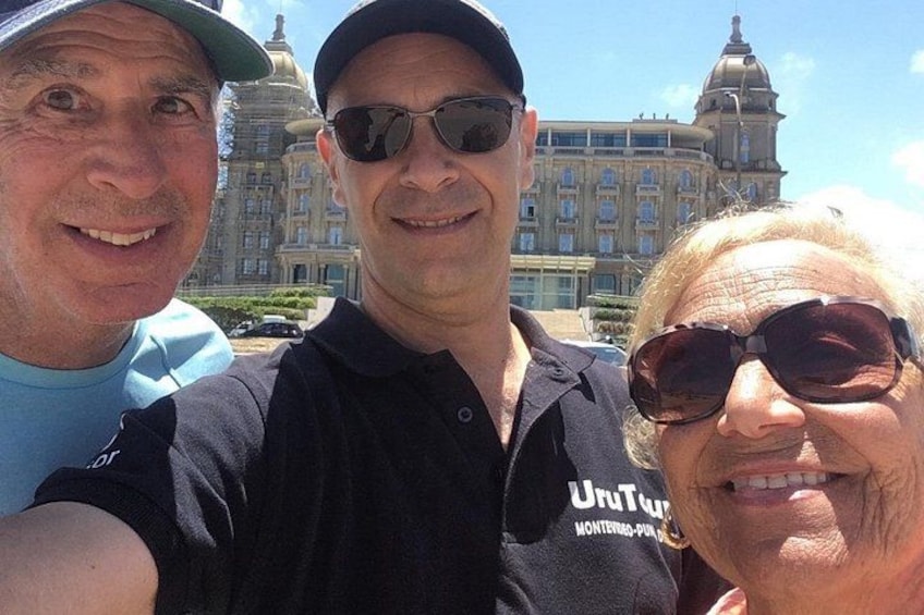 Tres personas frente a un edificio grande con cúpulas y columnas. 4