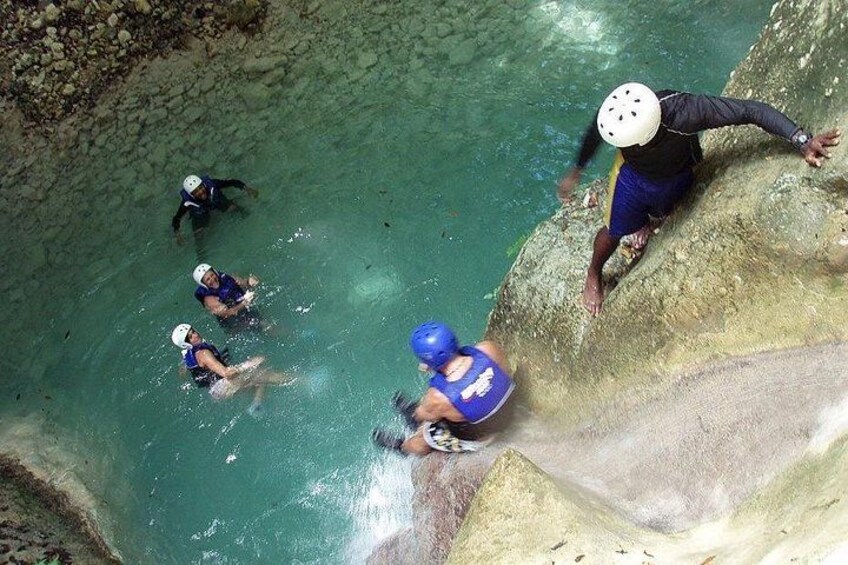Mensen nemen deel aan een wateractiviteit, mogelijk rafting in een heldere, rotsachtige rivier. 1