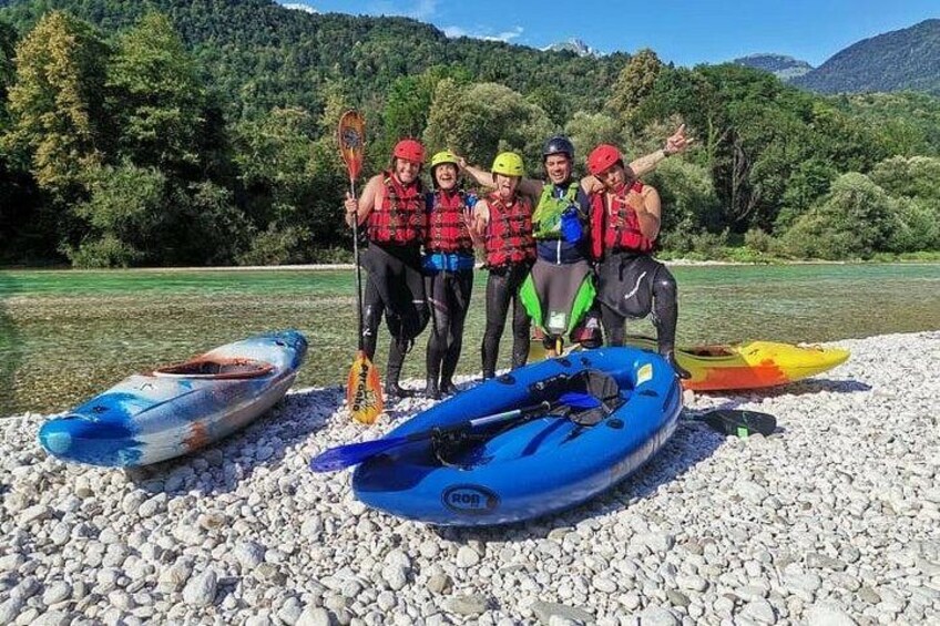 Un grupo de personas en una costa rocosa con kayaks y un río al fondo. 5