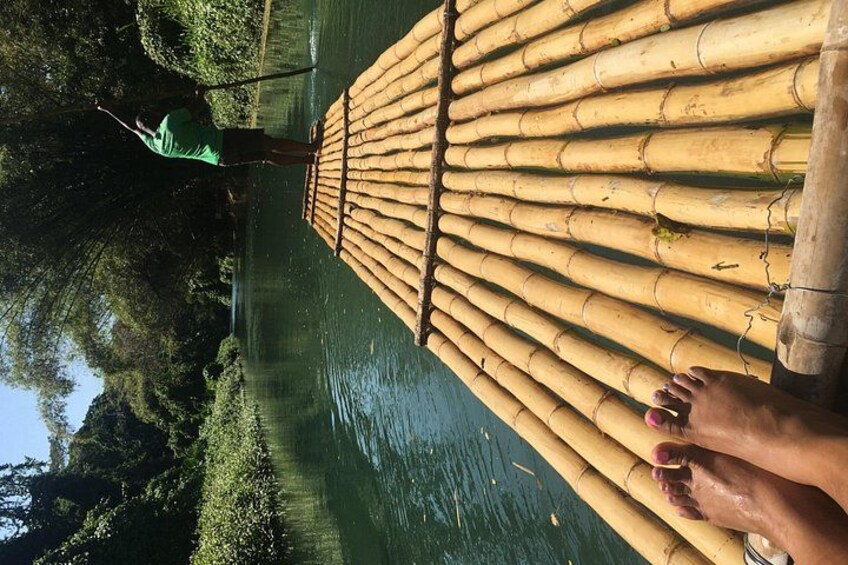 A bamboo raft on a river with a person standing on it. 4