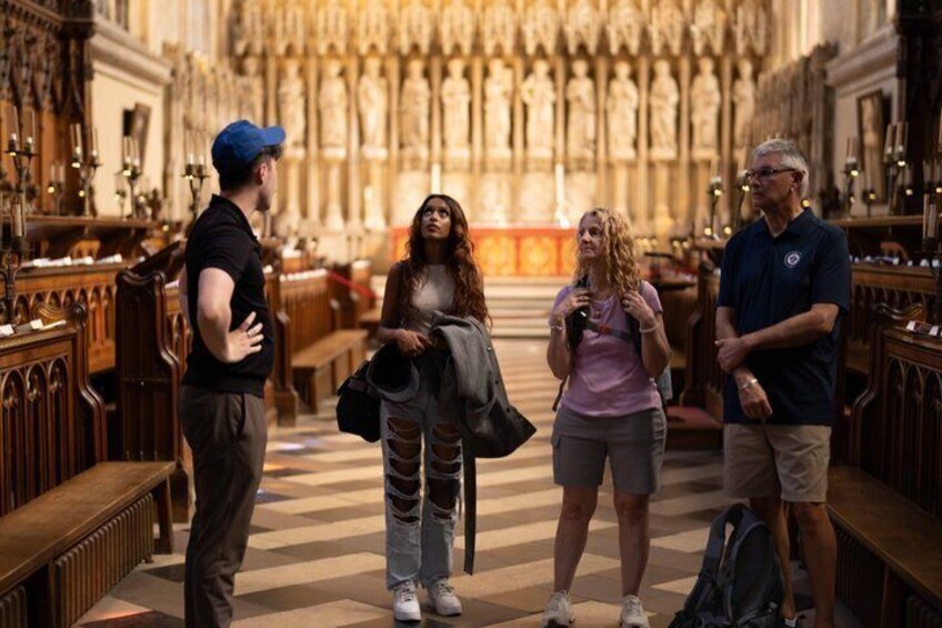 A group of people inside a church with high ceilings and wooden pews. 5
