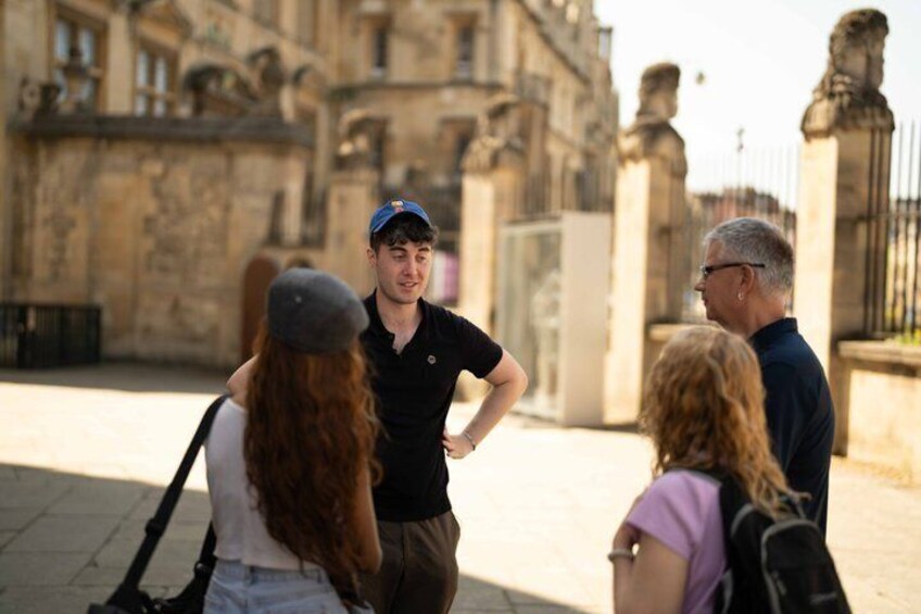 A group of people standing on a paved area with historical buildings in the background. 3