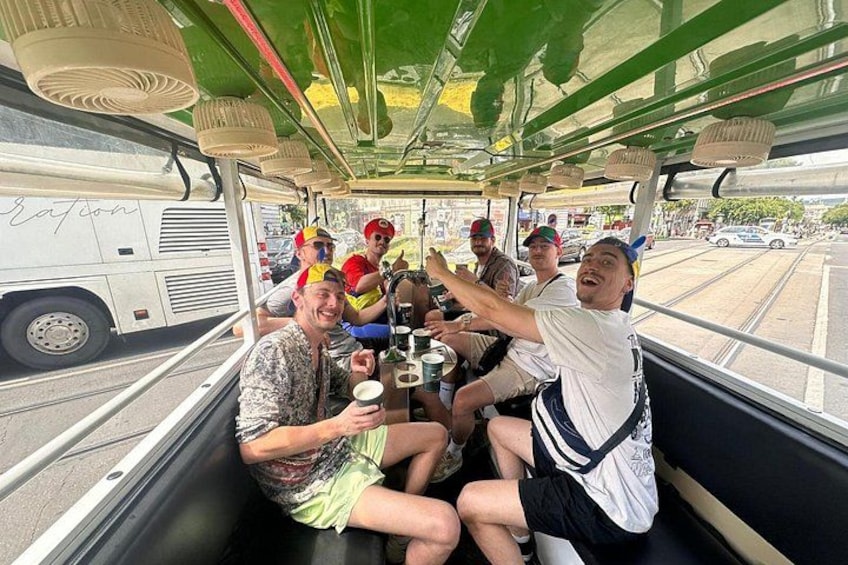 A group of people on a boat with a green canopy, holding drinks and enjoying themselves. 4