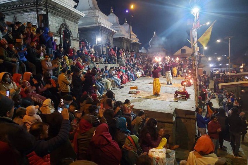 A large crowd gathered around a stage with a performer in traditional attire. 1