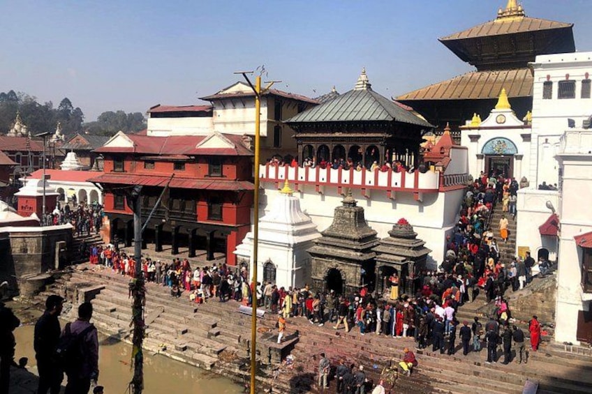 A crowded temple complex with multiple buildings and steps leading up to the main structure. 3