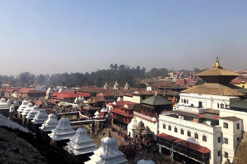 A cityscape with numerous traditional buildings, including white domed structures and red-roofed buildings. 4