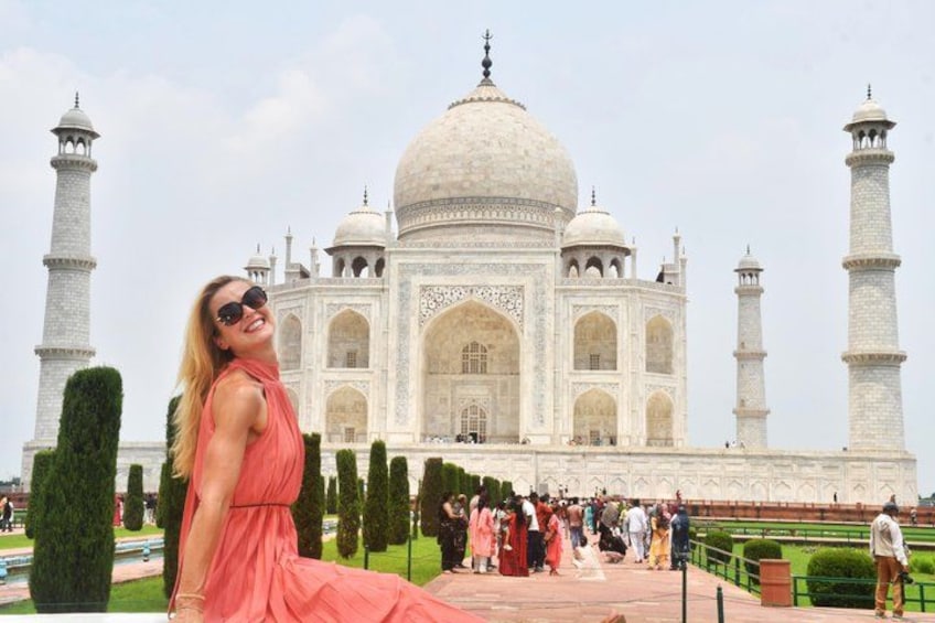 Il Taj Mahal con una persona in abito rosa in primo piano. 1