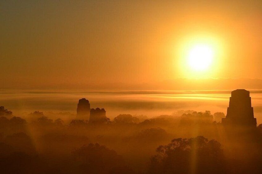 A sunrise over a landscape with rock formations and trees. 5