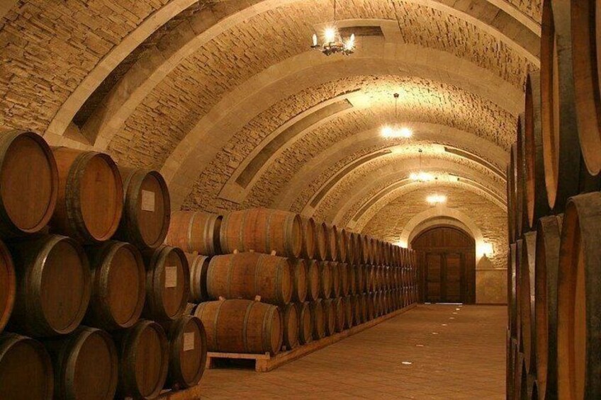 Une cave à vin avec des barriques en bois et des voûtes en arc. 2