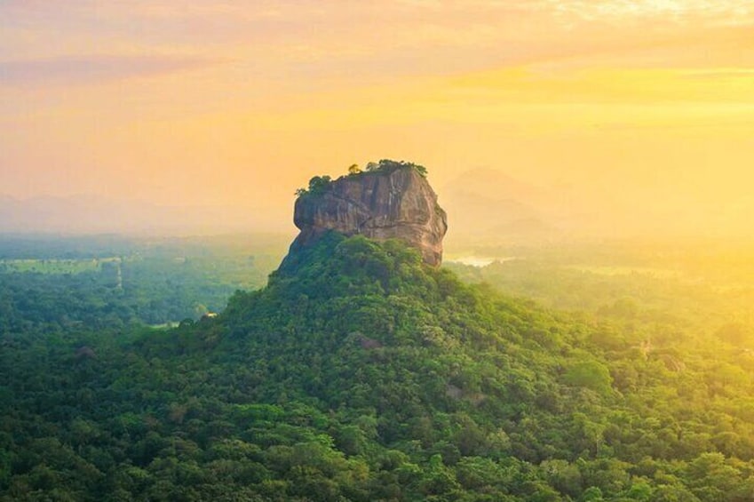 A mountain peak with a forested base and a clear sky. 1