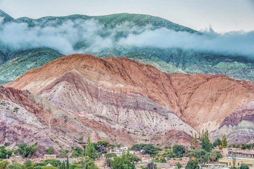 Un paisaje montañoso con un pueblo a su base. 1