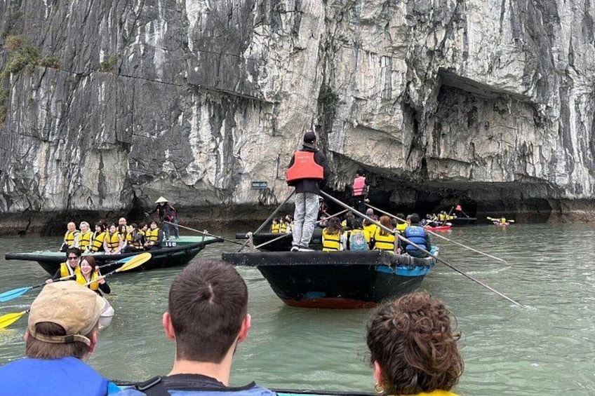 Een groep mensen in boten op een rivier, met rotsachtige kliffen op de achtergrond. 2