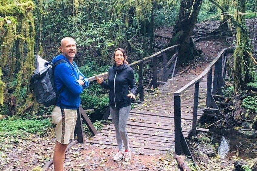 Dos personas en un puente de madera en un área boscosa. 5