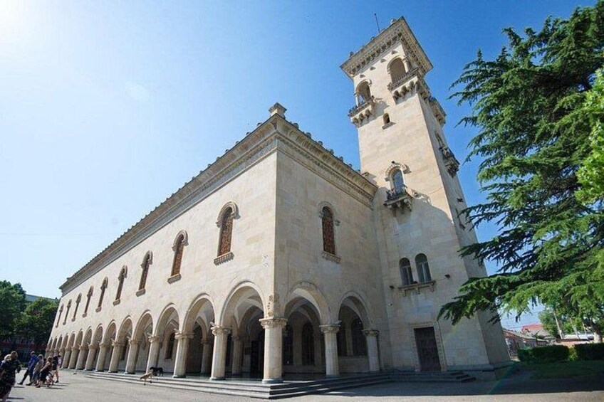 A large historical building with a prominent tower and arched windows. 2