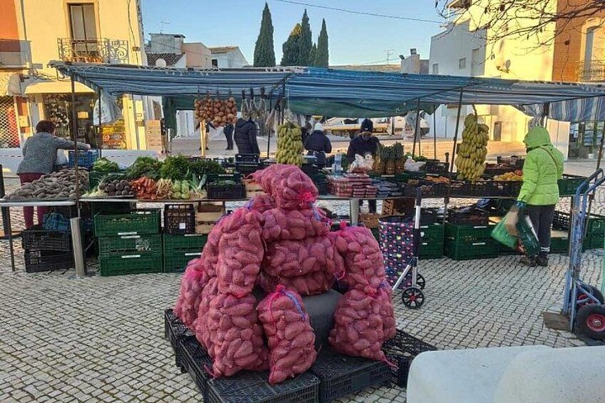 Ein Markt mit Gemüseständen, darunter ein großer Haufen pinkfarbener Früchte und Gemüse. 5