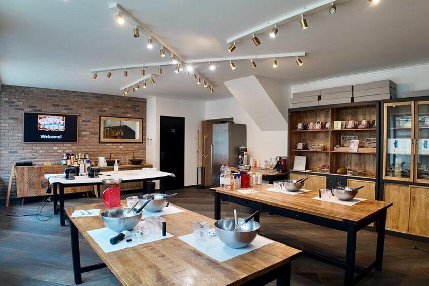 A modern kitchen with wooden tables, cooking utensils, and a brick wall. 4