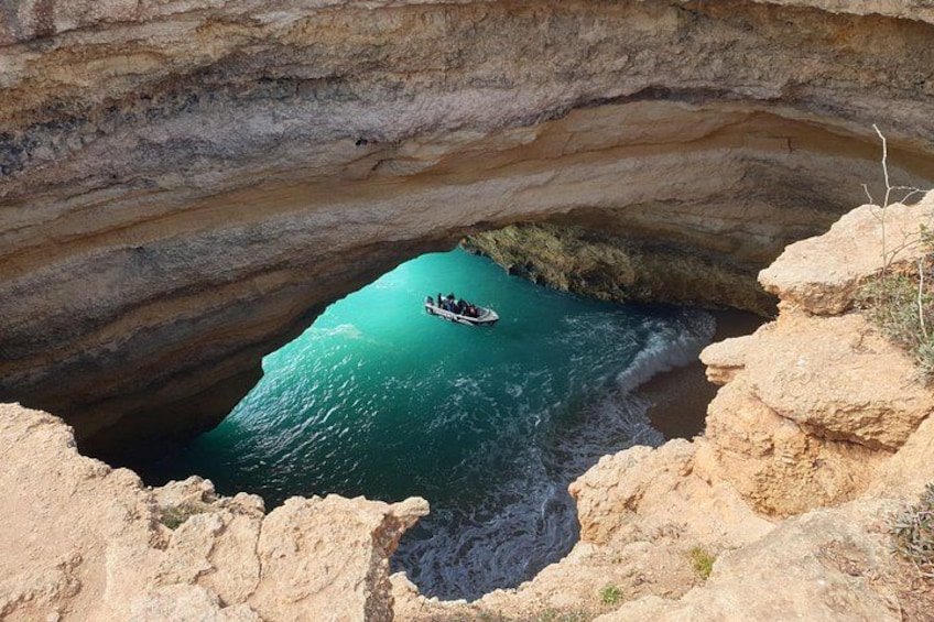 Ein Boot in einer natürlichen Felsformation mit klarem, blauem Wasser. 2