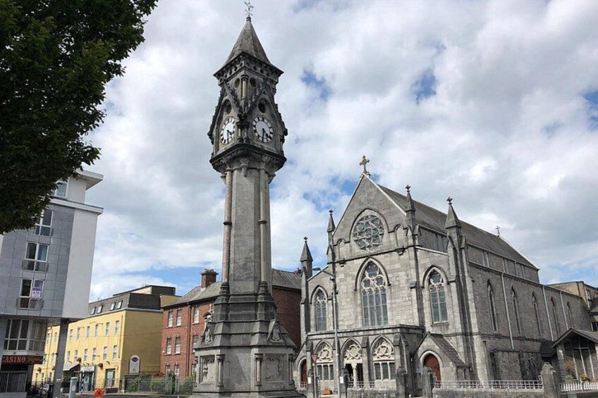 A historic church with a clock tower, arched windows, and a statue. 2