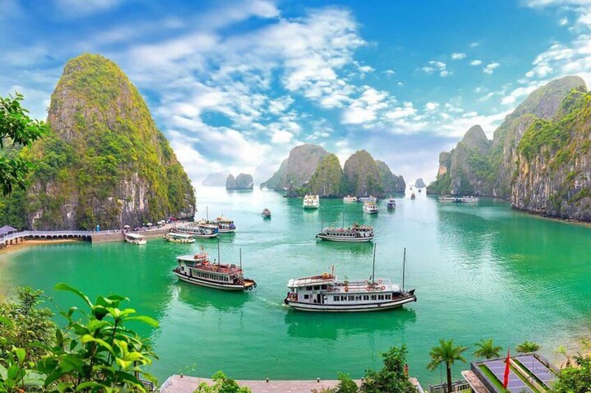 A river with boats, green cliffs, and a clear sky. 5